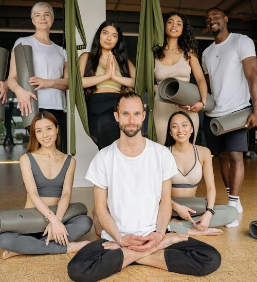 Diverse group of people smiling during a yoga class.