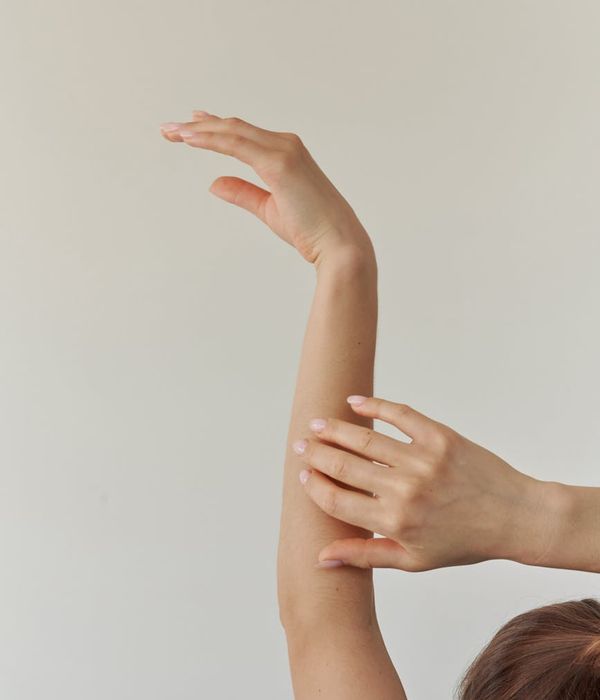 Woman in a peaceful yoga pose against a light blue background.